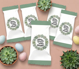 White bags with green accents and plant-themed designs on a beige surface with plants and eggs.