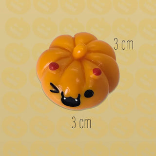Pumpkin-shaped object with a face on a yellow background with measurement markings.