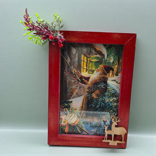 Decorative picture frame with a winter scene painting and red border on a light gray background