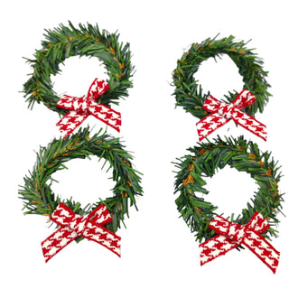 Four green Christmas wreaths with red and white bows on a white background