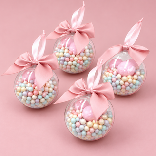 Four clear Candyland baubles with pastel candy-style beads and pink satin bows on a blush pink background