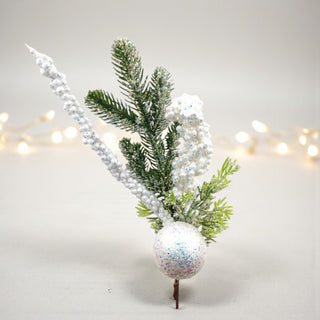 Decorative arrangement with greenery, a white ornament, and string lights on a light background. Winter Wonderland Aesthetic