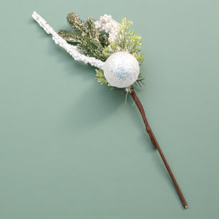 Decorative wand with a glittery sphere and greenery on a light green . Winter Wonderland Aesthetic Sage background