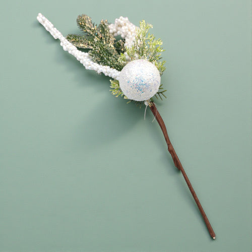 Decorative wand with a glittery sphere and greenery on a light green . Winter Wonderland Aesthetic Sage background