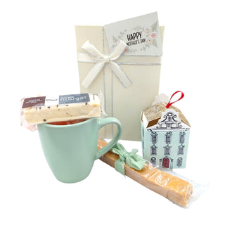 Gift set with a mug, tea bags, and a small box on a white background