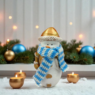 Decorative snowman figurine with a blue and white scarf, gold top hat, and holding a candle, surrounded by candles and Christmas decorations.