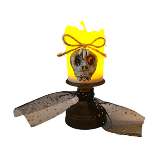 creep face on side of yellow candle light with a string bow and a bronze candle holder wrapped by a mesh black material and golden flecks