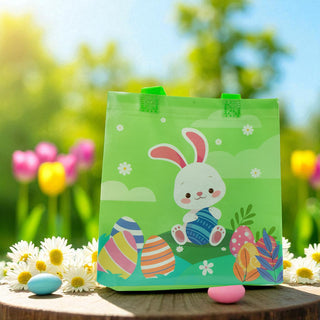 Green Easter bag with bunny design on a wooden surface with flowers and eggs.
