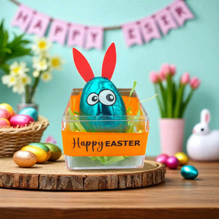 Easter-themed display with a blue egg in a clear container, bunny ears, and 'Happy Easter' banner.