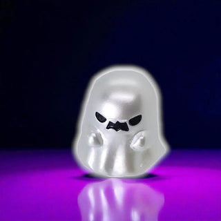 Ghost-shaped object with a dark face on a reflective purple surface