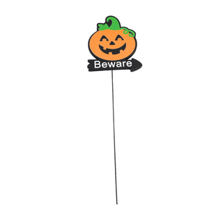 orange and green pumpkin on top of a beware sign