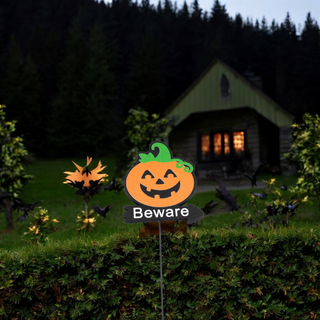 orange and green pumpkin on top of a beware sign
