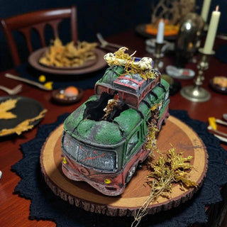 Model train set on a wooden board with decorative elements on a table.