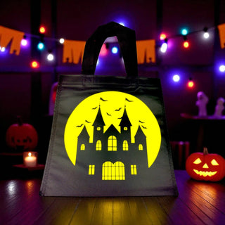 Halloween-themed tote bag with a haunted house design on a festive background.