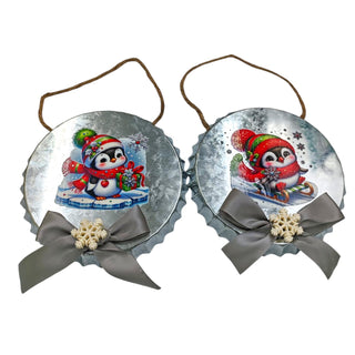 Two Christmas ornaments with penguins and ribbons on a white background