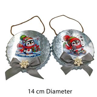 Two Christmas ornaments with penguins and ribbons on a white background