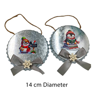 Two Christmas-themed bottle cap ornaments with penguins and snowflakes on a white background.