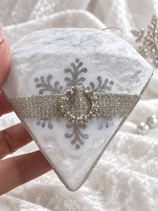 Hand holding a white velvet diamond Christmas bauble to show size