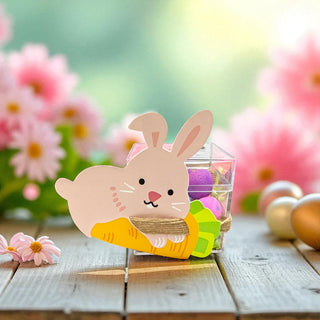 Decorative bunny with Easter eggs on a wooden surface with flowers in the background