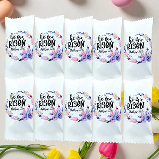 Packets with 'He is Risen' text and floral designs on a white background with flowers.