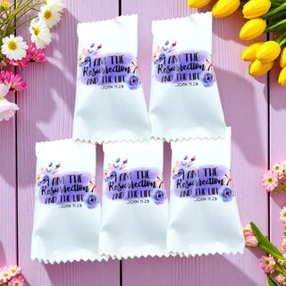 White candy packages with religious text and flowers on a pink wooden background