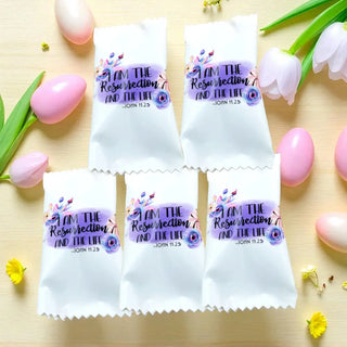 White packages with religious text and Easter eggs on a wooden surface