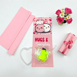 Pink gift box with cartoon characters, green toy, and pink flowers on a white background