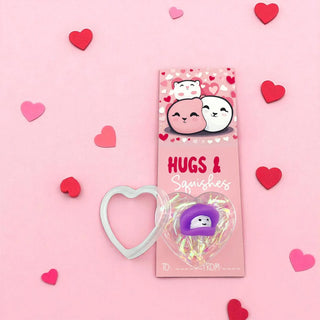 Pink packaging of 'Hugs & Squishies' with cartoon characters on a pink background with heart decorations.
