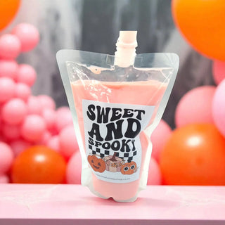 Pink pouch with 'Sweet and Spooky' label against a colorful background
