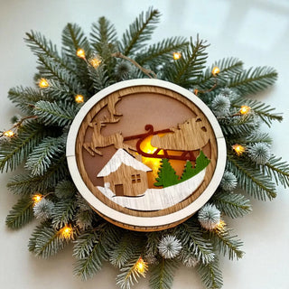 Decorative wooden ornament with reindeer and sleigh design on a Christmas wreath with lights.
