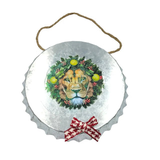 Decorative metal sign with a lion's face surrounded by greenery and a red bow on a white background.