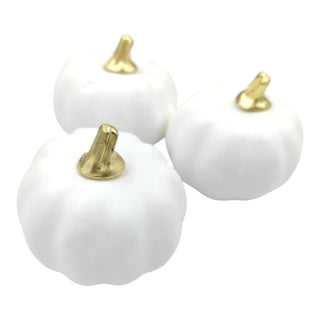 Three white pumpkins with gold stems on a white background