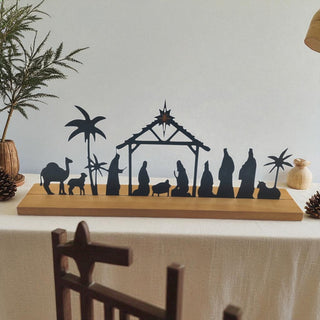 Silhouette nativity scene on a wooden stand with a white background