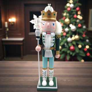 Decorative nutcracker figure with a crown and staff on a white background for a sage Christmas aesthetic