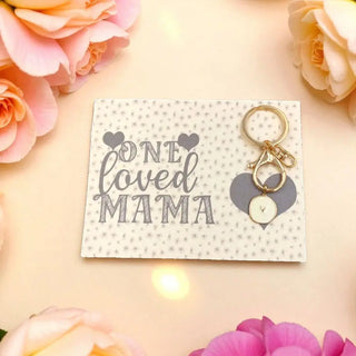 Keychain with 'ONE LOVED MAMA' card surrounded by pink flowers on a light background