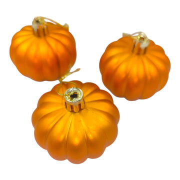 Three orange pumpkin ornaments on a white background