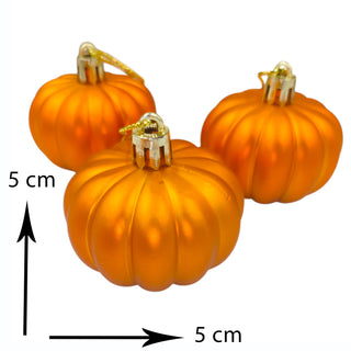 Three orange pumpkin ornaments with gold stems on a white background, showing measurement details.