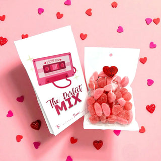 Cassette tape-shaped gift with 'The Perfect Mix' text and heart-shaped gummy bears on a pink background with heart decorations.