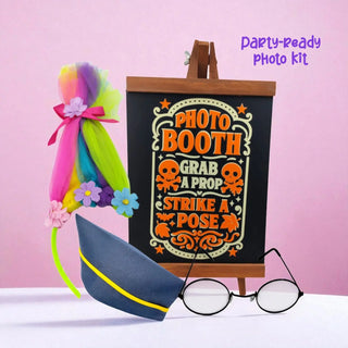 Photo booth prop set with colorful wig, glasses, and sign on a pink background