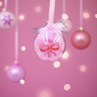 Pink Christmas ornament with a bow on a Christmas tree with lights for a Ballet Nutcracker theme