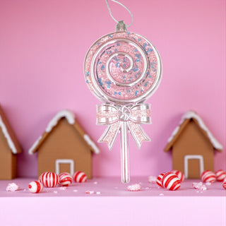 Decorative lollipop ornament with a pink background and gingerbread houses.