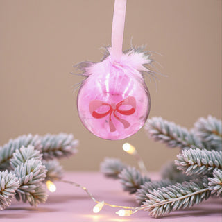 Pink Christmas ornament with a bow on a Christmas tree with lights for a Ballet Nutcracker theme