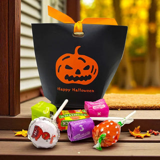 Halloween-themed candy bag with pumpkins and 'Happy Halloween' text, surrounded by colorful candies on a wooden surface.