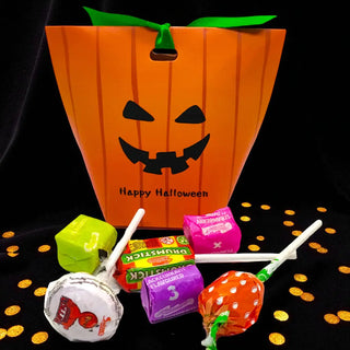Halloween-themed candy bag with lollipops and small packages on a black background.