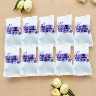 White packages with religious text and graphics on a wooden surface with flowers.
