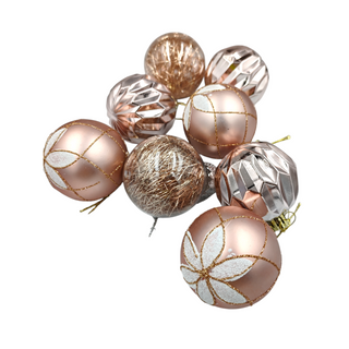 Decorative Christmas ornaments with gold and rose gold finishes on a white background