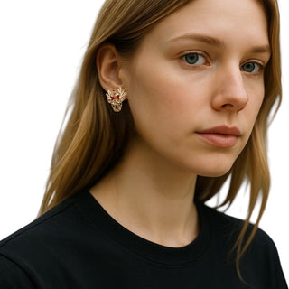 Close-up of a woman wearing a decorative earring on a plain background