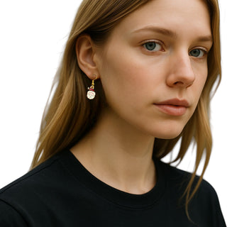 Close-up of a woman wearing gold earrings with a white background