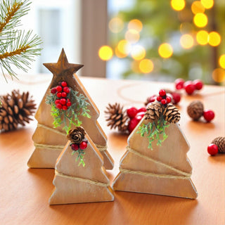 Wooden Christmas tree decorations with pine cones and berries on a wooden surface.