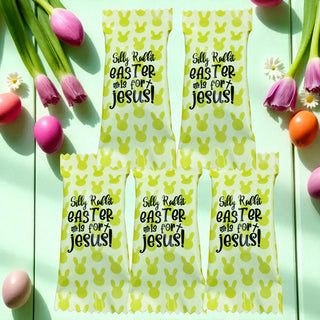 Four yellow Easter bags with text on a wooden surface with Easter eggs and flowers.